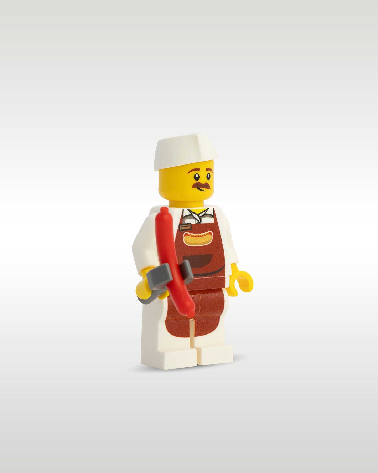 Side profile of the custom toy brick vendor minifigure holding a reddish-brown micro-scale hot dog sausage accessory
