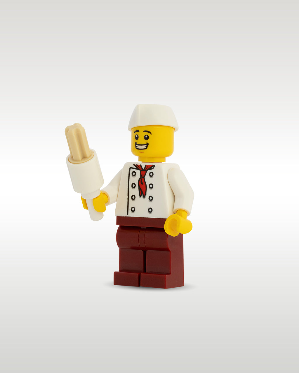 Front view of the Trader Bricks custom printed food vendor minifig proudly holding a miniature tan toy churro stick