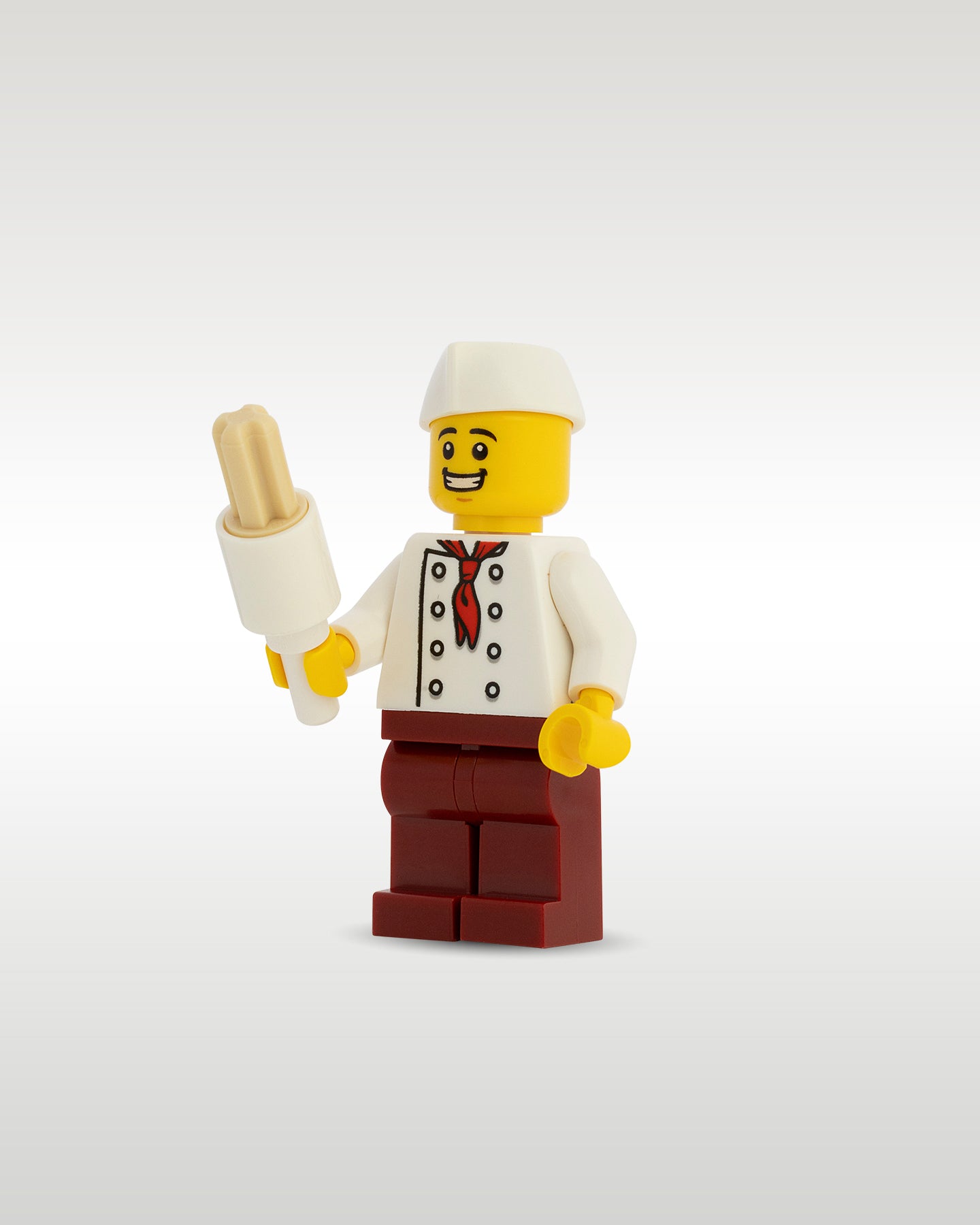 Front view of the Trader Bricks custom printed food vendor minifig proudly holding a miniature tan toy churro stick