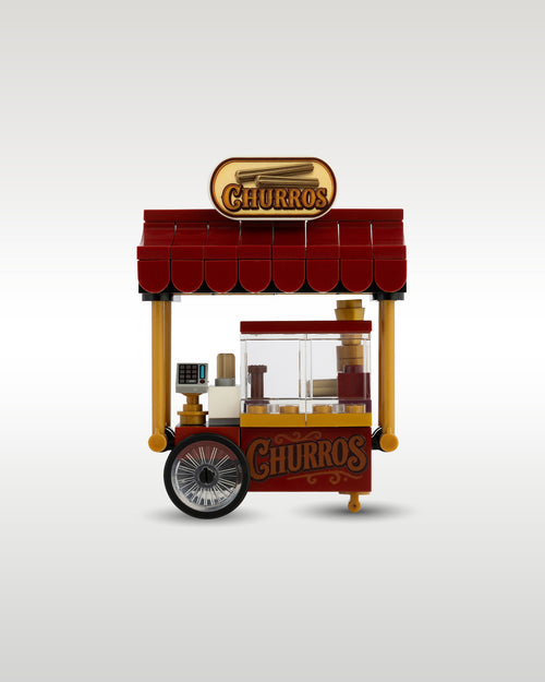 Front close-up view of the Trader Bricks custom toy brick churro stand, highlighting the detailed glass display case and custom printed oval overhead sign