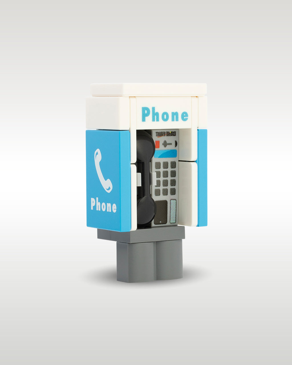 angled profile view of the custom toy brick public phone booth, showcasing the side graphic tile with a white telephone icon and the internal printed button keypad