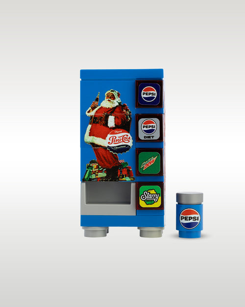 Custom brick-built Christmas Pepsi vending machine MOC set by Trader Bricks, featuring a blue holiday Santa Claus graphic panel and a matching miniature blue soda can accessory