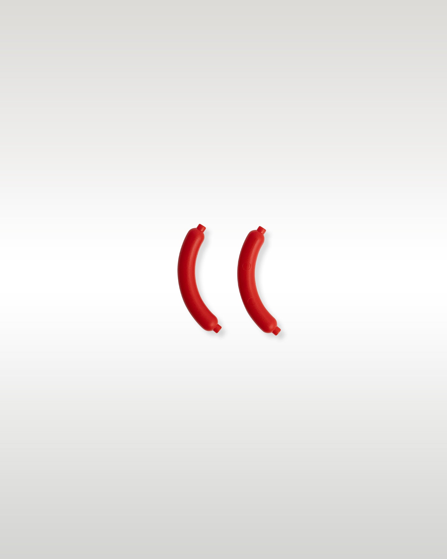 Two custom molded reddish-brown micro-scale hot dog sausage food accessories included with the Trader Bricks street vendor set