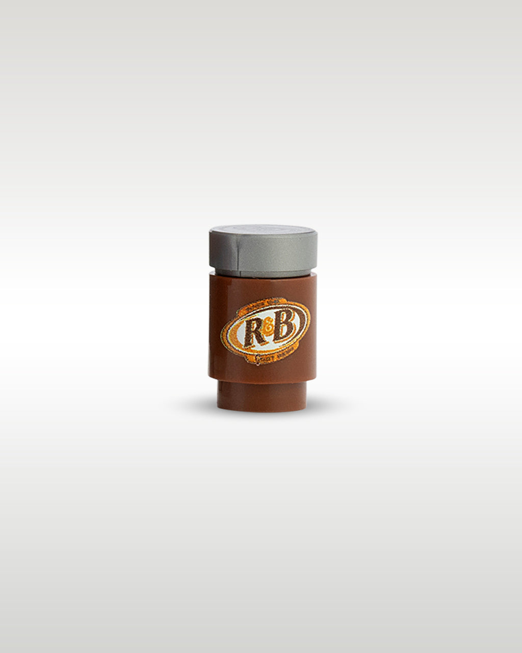 Front close-up view of the custom printed R&B Root Beer soda can accessory by Trader Bricks, featuring an oval parody logo on a brown 1x1 round brick with a silver top